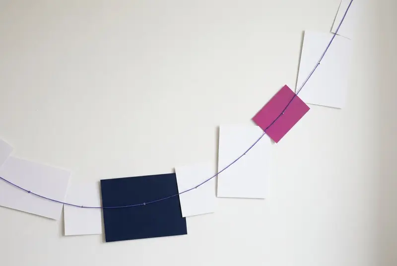 A sequence of cards strung along a single purple thread